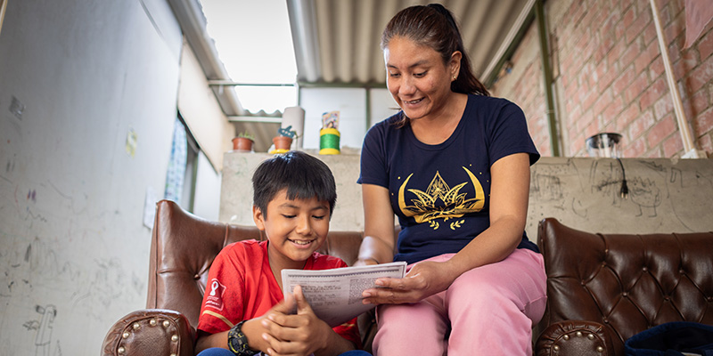 Mathias en zijn moeder Tatiana uit Peru lezen een brief van Mathias' sponsor.