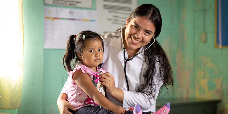 Mariam uit Guatemala controleert een meisje met een stethoscoop.