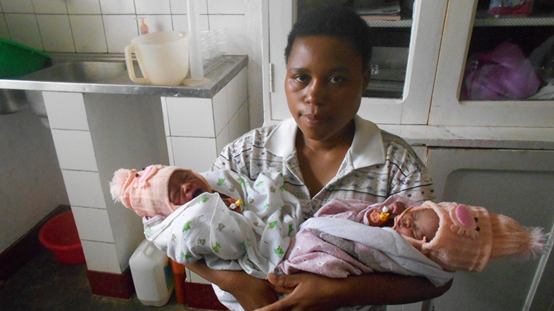 Jeannette uit Rwanda staat met haar pasgeboren tweeling op de arm in het ziekenhuis.