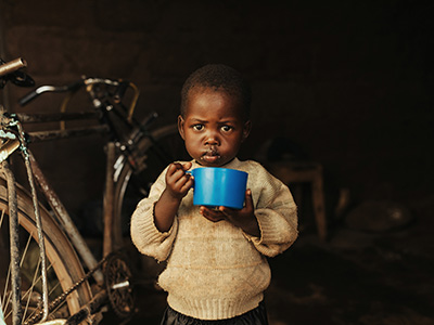 Lena uit Kenia houdt een blauwe beker vast.